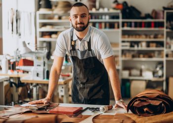 Male designer and leather tailor working at a factory